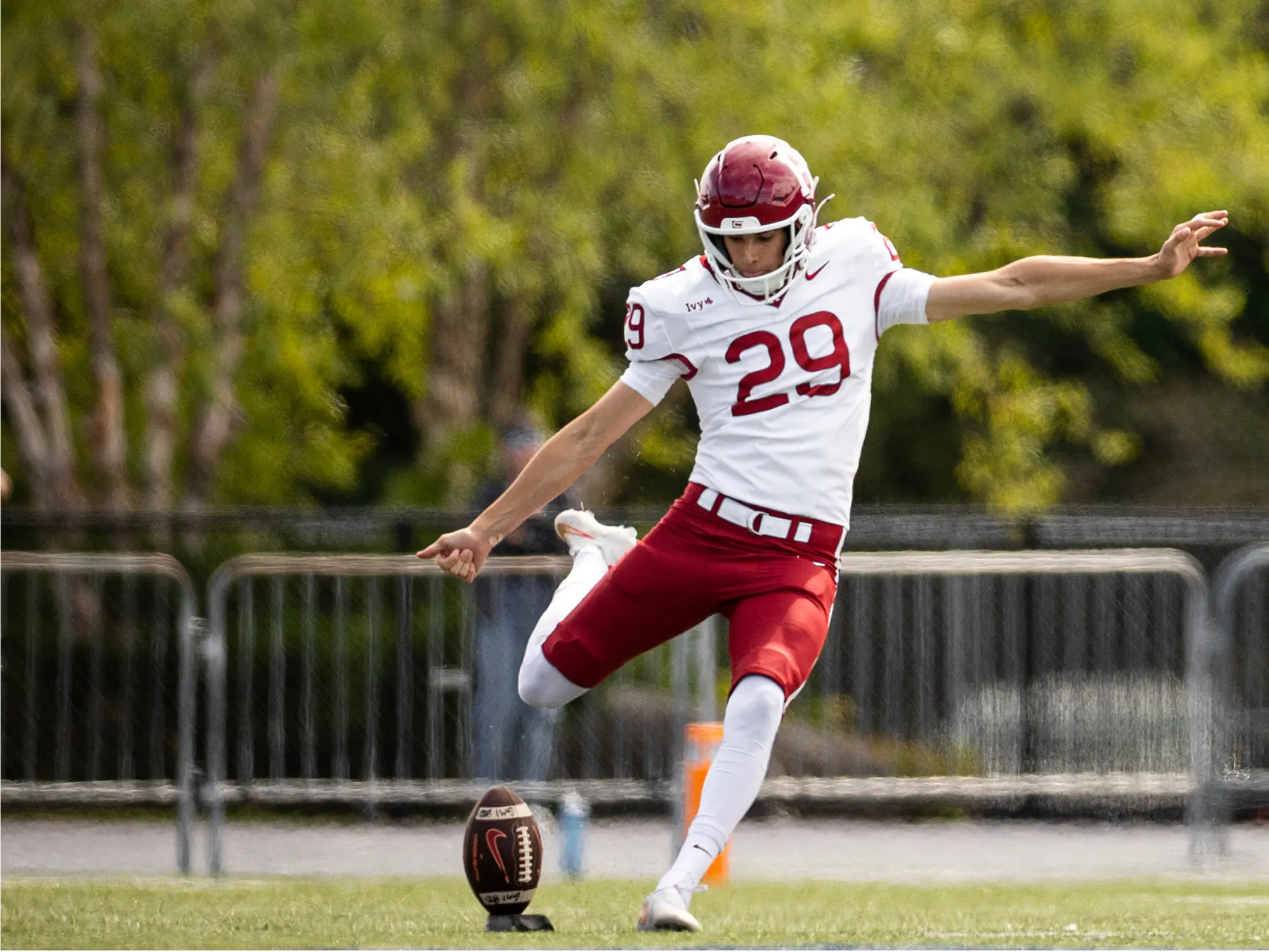Havard football player #29 prepares to kick the football