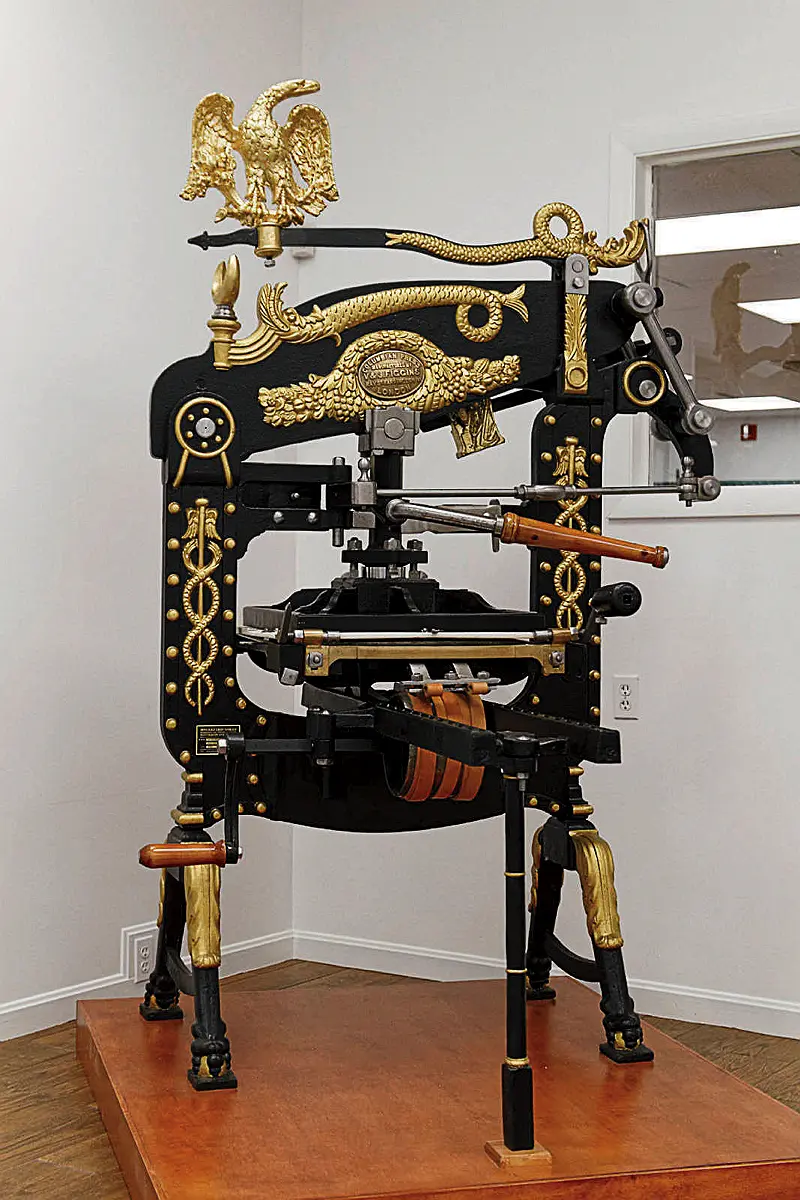 Ornate 1851 cast-iron letterpress with intricate gold detailing and eagle decoration.