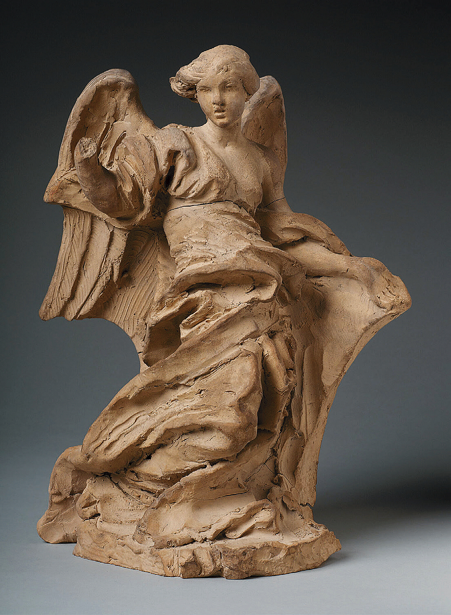 A clay sculpture of a robed angel. 