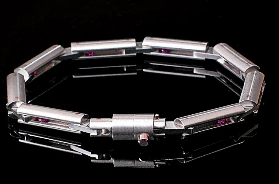 Industrial-style silver bracelet with rectangular links and small purple accents.