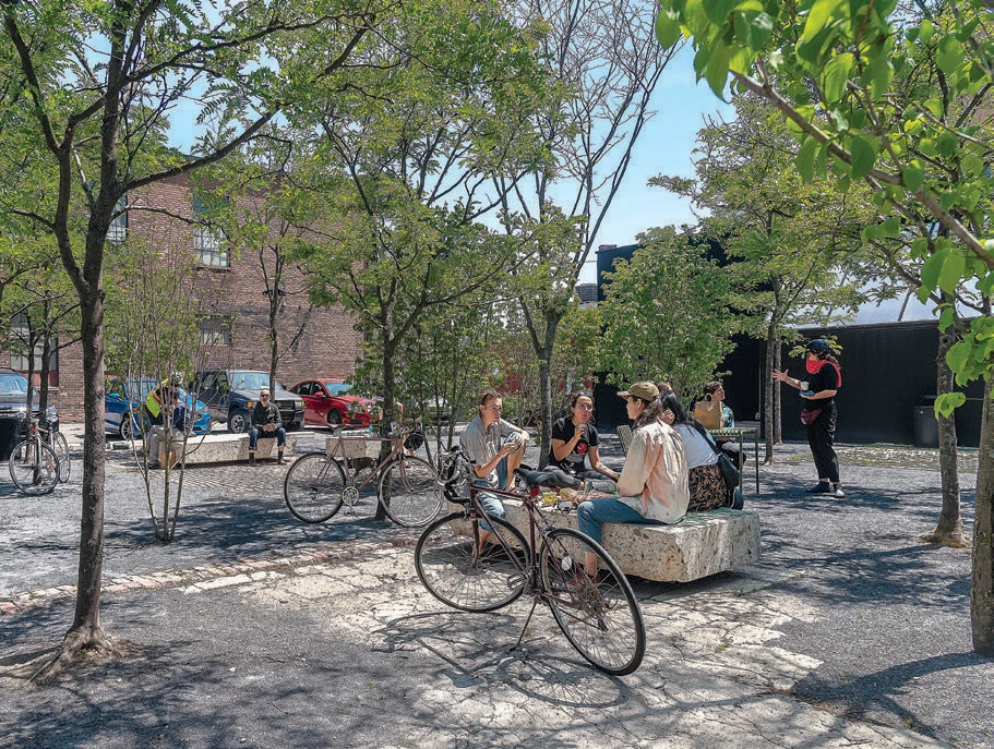 Bicycles and people sitting on stoops at Core City Park Detroit, MI