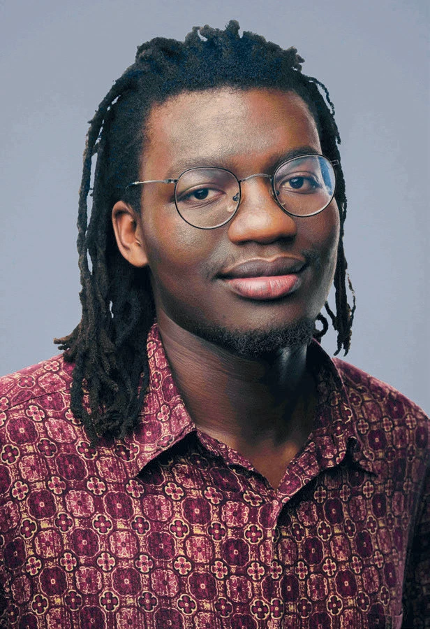 Tom Osborn wearing a patterned maroon shirt, facing camera.
