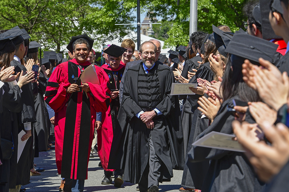 President Garber and Dean Rakesh Khurana processing through a line of students in caps and gowns