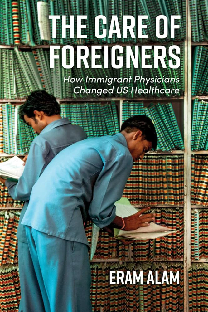 Book cover for "The Care Of Foreigners: How Immigrant Physicians Changed US Healthcare" by Eram Alam with two men in light blue uniforms hunched over taking notes in front of a wall of books