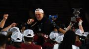 Coach Murphy is held up high by players in celebration