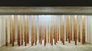 Yamamoto's installation, made of 20 orange tubes that stretch from floor to ceiling in a white room. 