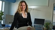 Naomi Bashkansky sits on a table with a chess board behind her. 