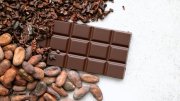 a bar of chocolate next to a pile of cacao beans