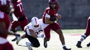 Holy Cross player attempts to tackle Harvard player 1 who is running with ball
