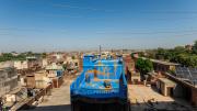 view of rooftop buildings and a colorful roof painted blue and gold as an art display