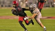 Harvard player 6 runs with the ball as UNH player attempts to tackle him
