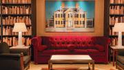 Library looking room with bookcases and a red sofa and accent chairs 