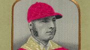 Portrait of Tom Cannon in a striped jockey uniform and matching cap.