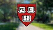 Harvard FAS shield in the foreground with Harvard Yard in a blurred background