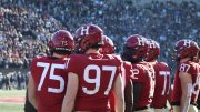 Crimson footballers on the sideline of the 2022 Harvard-Yale game