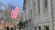 University Hall with a flag over the John Harvard Statue