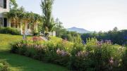 Garden view of Aspet, with vibrant flower beds and Mount Ascutney in the background.