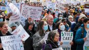 Crowd at Boston science rally holding protest signs opposing research funding cuts