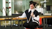 Jessica Shand holds a flute, seated in a music lab. 