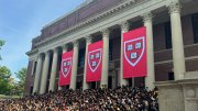 Commencement flags at Widener with students gathered on steps