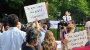 protestors outside Harvard Science center holding signs saying "Do you love the world, Harvard?" and "The world has your back, Harvard."