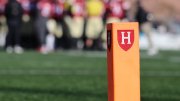 orange post on a football field with the Harvard Athletics shield