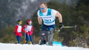 A man skiing intensely in the snow, with two spectators in the background.