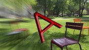 Red letter "A" overblurred lawn with colorful chairs in the background.