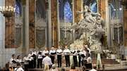 A group of choir singers performs in a cathedral
