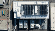 Aerial view of a large industrial data center facility with a flat roof and various equipment.