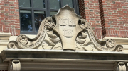 Architectural stonework featuring floral motifs and an inscription reading Veritas, set against the brick exterior of Widener Library.