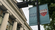 Harvard Law School exterior building to the left; to the right a lamp post with Harvard Law School banners