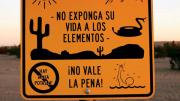 Near Winterhaven, California, an official sign faces south to warn illegal immigrants of dangers in the desert trek&mdash;heat, rugged terrain, rattlesnakes, lack of drinking water, a chance of drowning in a nearby canal&mdash;adding that it is not worth the risk.