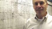 Kunkel with a six-foot-long map showing a portion of the area where the dystrophin gene is located within the human genome. This framed, hand-drawn original was started in 1983 and published in 1986, in the days before high-speed DNA sequencing. 
