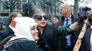Lady Gaga poses with a fan near the Science Center before the Sanders Theatre panel.