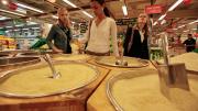 Kara Scarbrough, Alma Donohoe, and Edison examine the many varieties of rice for sale at this hypermarket.