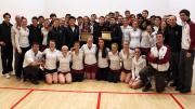 The men's and women's squash teams pose with their coaches—and their trophies.