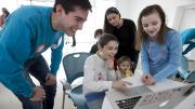 In the Ed Portal’s high-tech iStudio, Andreas Cruz ’17 teaches local students Jay Franks, age 11 (seated), and Cora Cloherty, age 10 (far right), how to use the Scratch programming language.