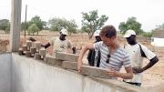 Jordan MacTavish, M.Arch. &rsquo;12, demonstrates how the Sinthian Cultural Center's patterned brickwork will allow for ventilation.