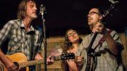 A bluegrass guitarist, banjoist, and singer perform on stage