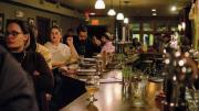 Guests sit along a long bar and face the stage