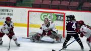 Photograph of several players competing for the puck in front of the Harvard goal