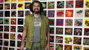 Bradley Scott Davis standing in front of a wall of frog paintings