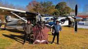 Alejandro Montagna standing in front of a small airplane wearing a wingsuit