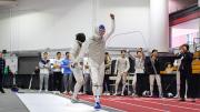 A fencer walks away from his opponent, holding up a fist