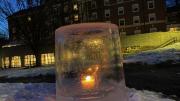 Close-up image of an "ice lantern" (a light set in an ice casing) in the snow on Radcliffe Quad