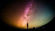 silhouette of person looking up from the ground at sky 