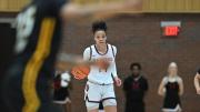Harmoni Turner '25 brings the basketball up the court.