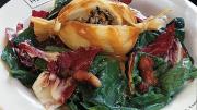 Duck tamale on spinach salad with a warm bacon and mustard dressing from Chez Henri
