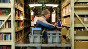 Nearly half of Harvard’s collection is housed at the Harvard Depository, a marvel of efficient off-campus storage. Library assistant Carl Wood reshelves books in the 30-foot-high, 200-foot-long stacks.